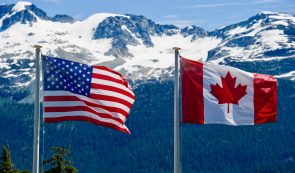 canadian and usa flag, mountain background