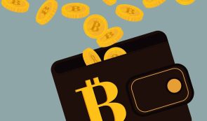 Bitcoin coins falling into a black wallet featuring a yellow Bitcoin symbol.
