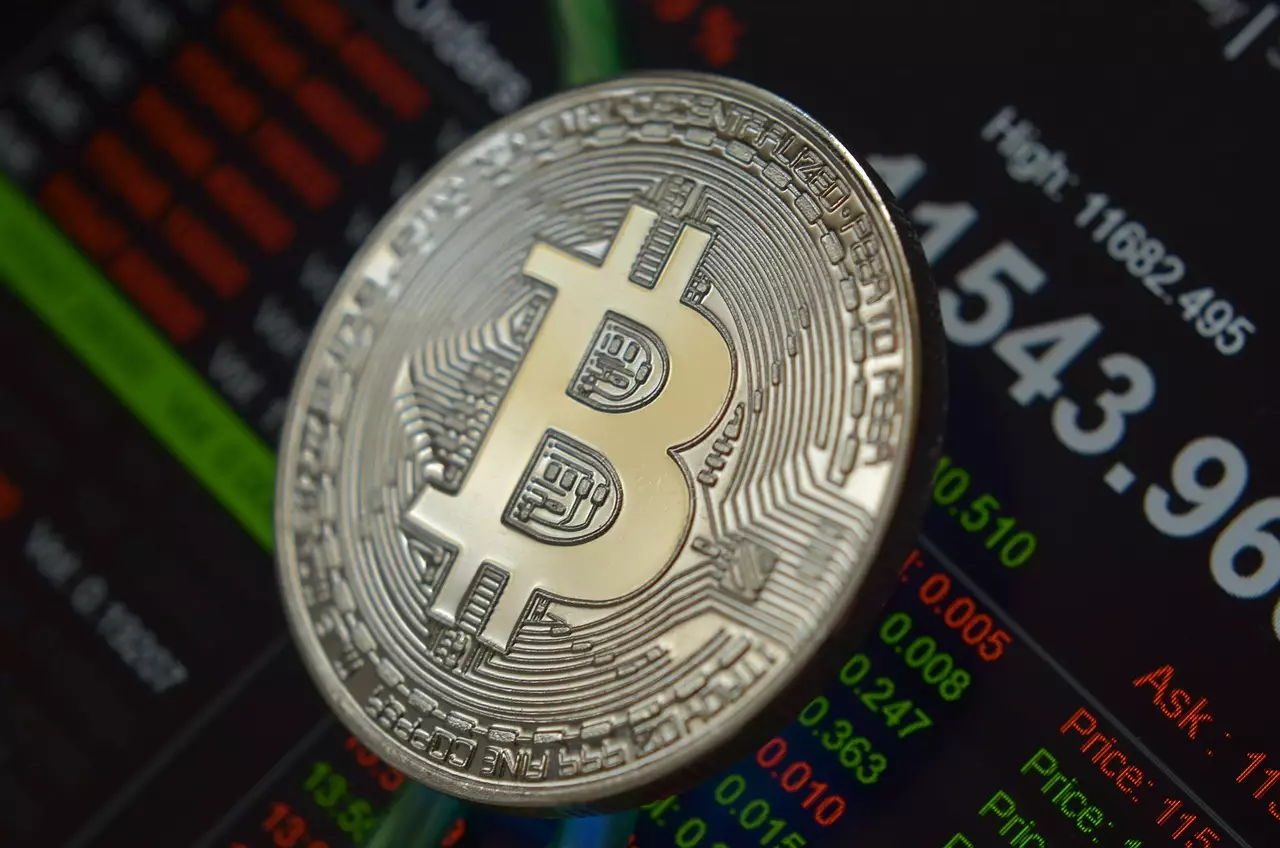 Physical Bitcoin token resting on a digital trading data background.