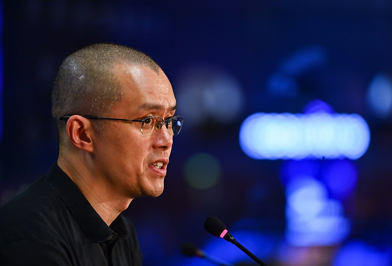 Binance founder Changpeng "CZ" Zhao speaking on a microphone during a conference.