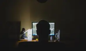 Person staying in th dark infront of the computer