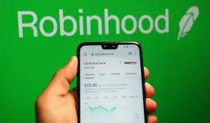 Smartphone displaying the Robinhood app interface in front of a green brand backdrop.