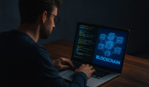 Man coding on a laptop with blockchain on his screen