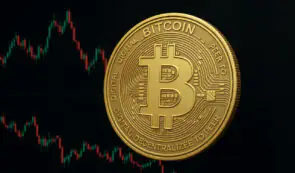 Physical Bitcoin (BTC) golden coin set against a dark background with red and green price action charts.