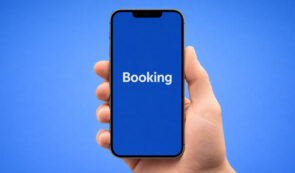 Hand holding smartphone with Booking app