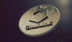 Physical Chainlink (LINK) token coin featuring the geometric logo and text set against a dark textured background.