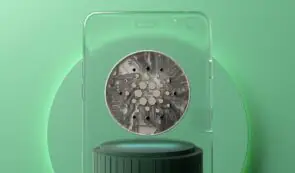 Cardano coin in glass panel on green background