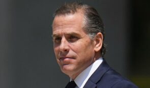 Portrait photograph of Hunter Biden wearing a dark suit and white shirt.