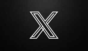 Alt: Stylized white geometric X logo centered against a dark, textured background.