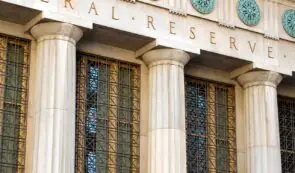 Stone columns and decorative metal windows on the Federal Reserve building’s facade.