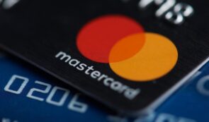 Close-up of a Mastercard payment card featuring the iconic red and yellow overlapping circles logo on a textured surface.